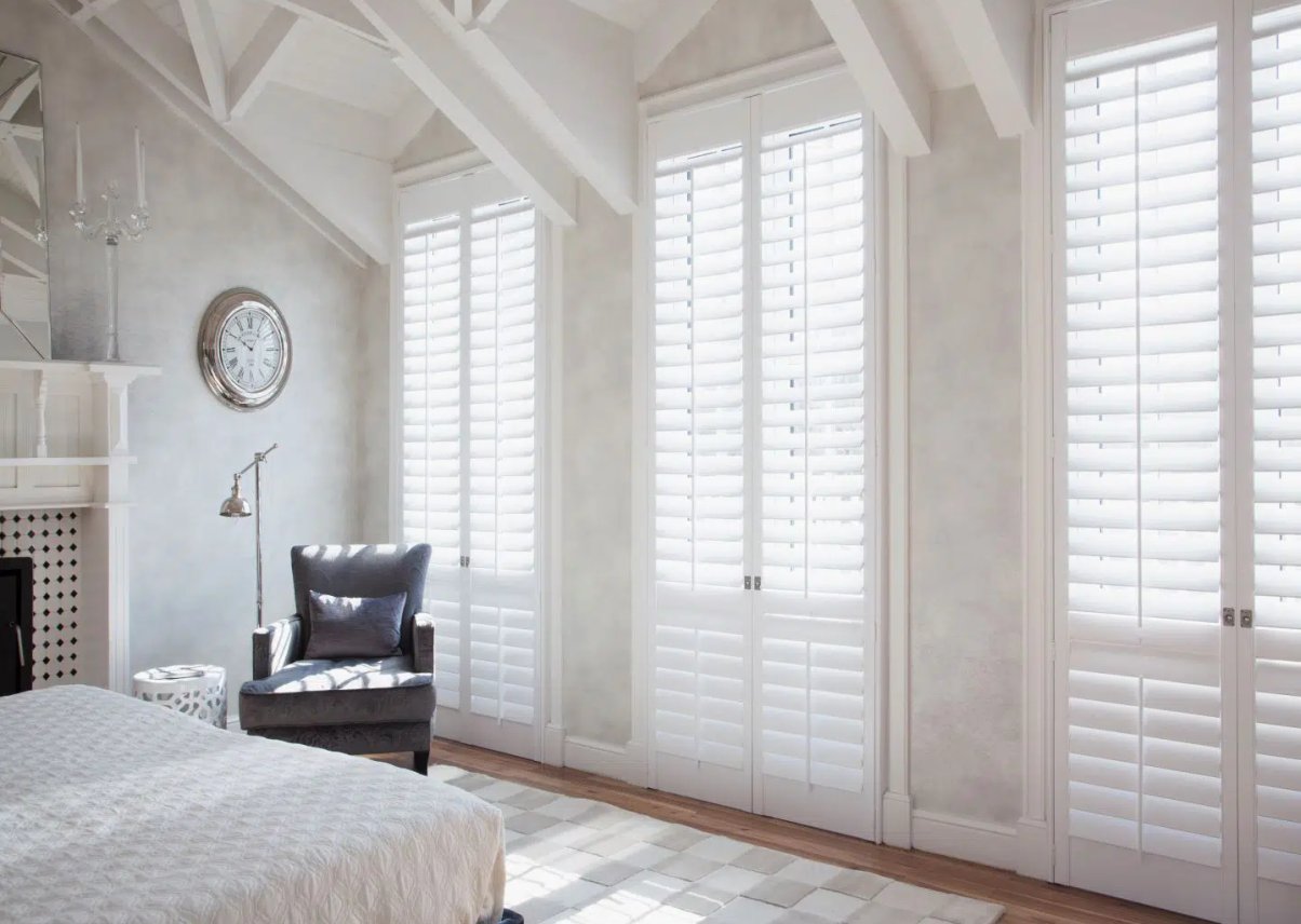 Living room with whole-home Norman Woodlore plantation shutters.