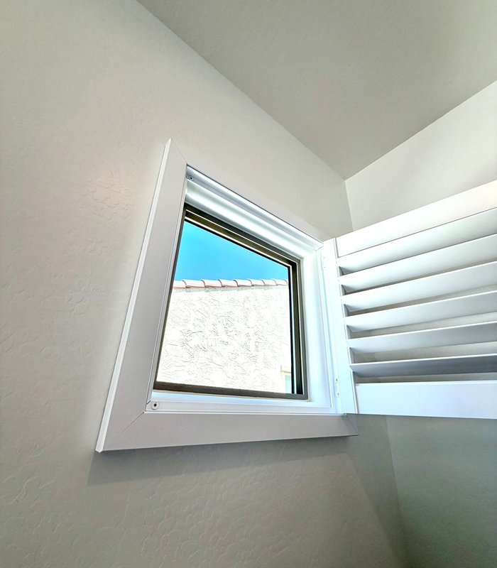 Angled specialty window shuttered to an irregular shape on a vaulted wall